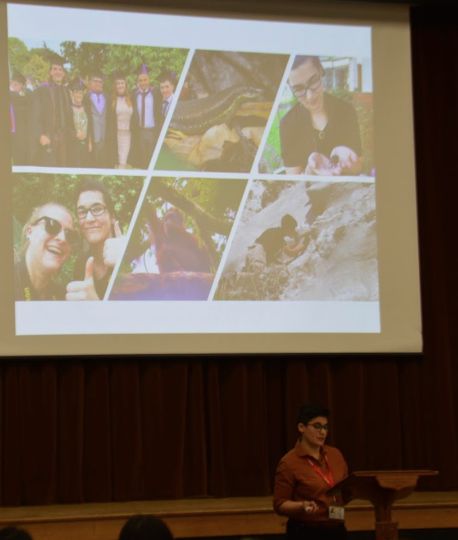 Photo showing a protected presentation featuring various photographs (graduation, wildlife and fieldwork photos) behind someone (me!) stood at a lectern.