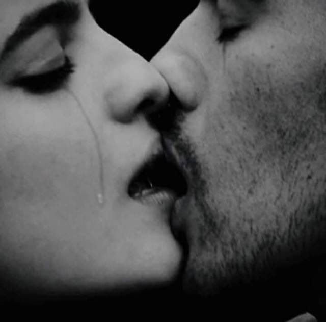 Un homme et une femme s'embrassant.
La femme a une larme qui lui coule sur la joue