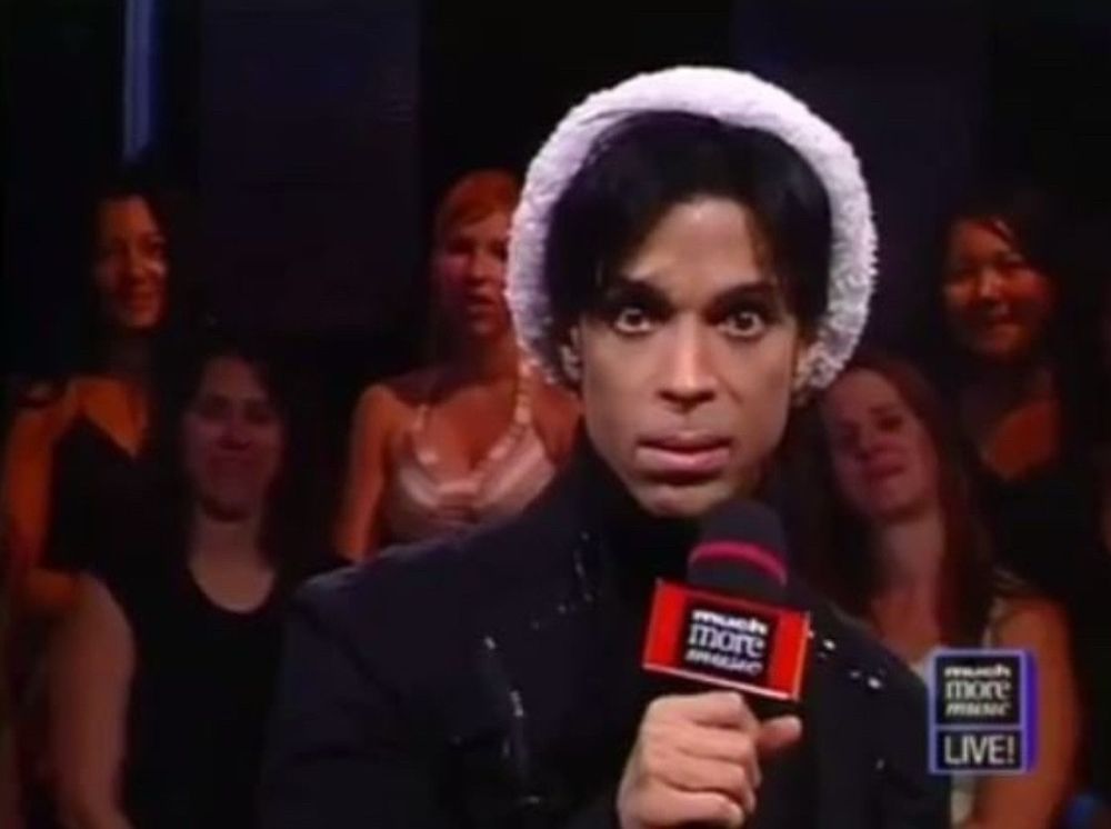 Prince holding a microphone, looking disgusted
