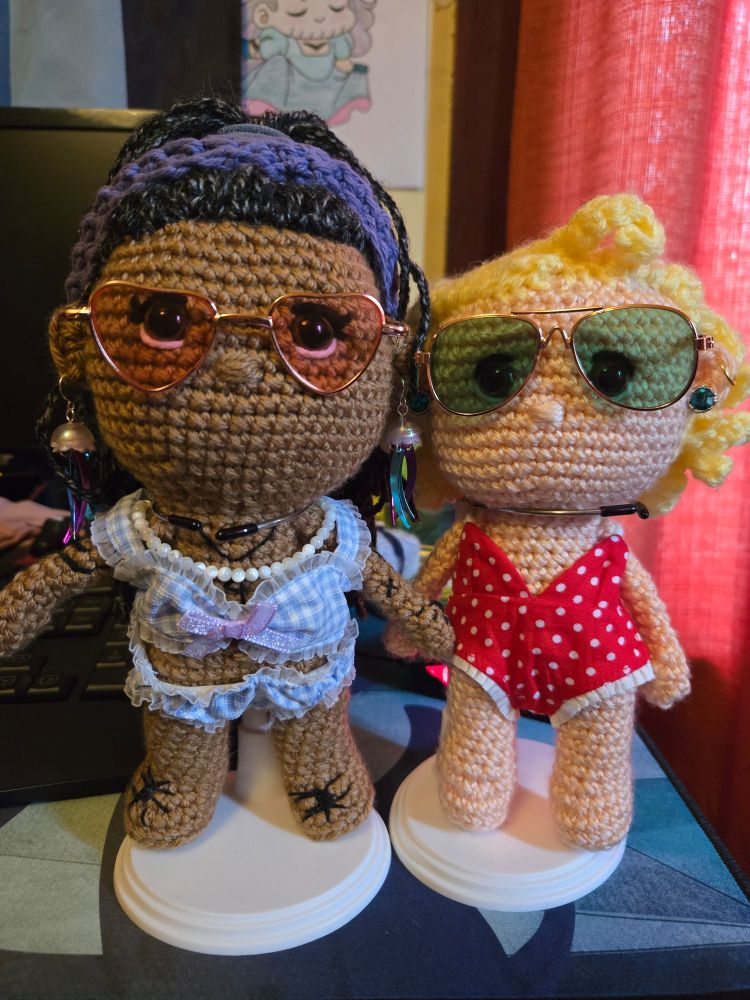 Photograph of yarn Ed in a blue gingham bikini and yarn Stede in a red and white polkadot one piece.
