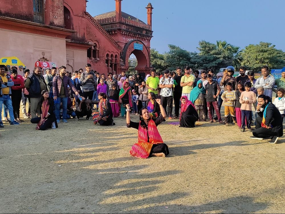 woman sitting down dancing surrounded by people in a circle