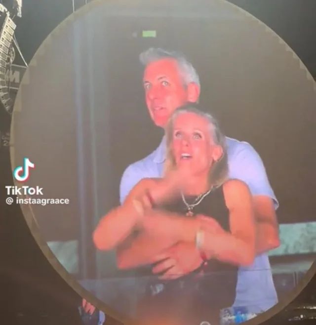 screenshot of two people caught maybe in an affair on the jumbotron at a coldplay concert