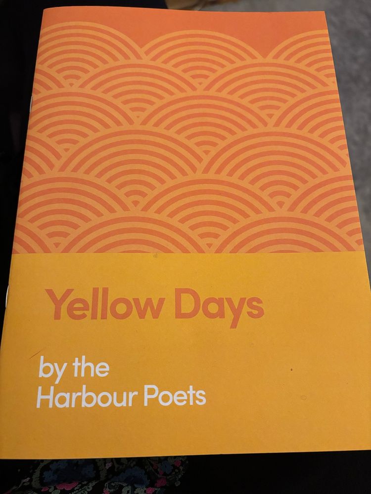 Photo of the front cover of “Yellow Days” by the Harbour Poets. Yellow background with simplified geometric sun semi-circles. 