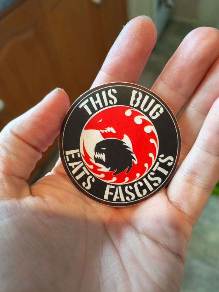 A circular stocked with the slogan "this bug eats fascists" 