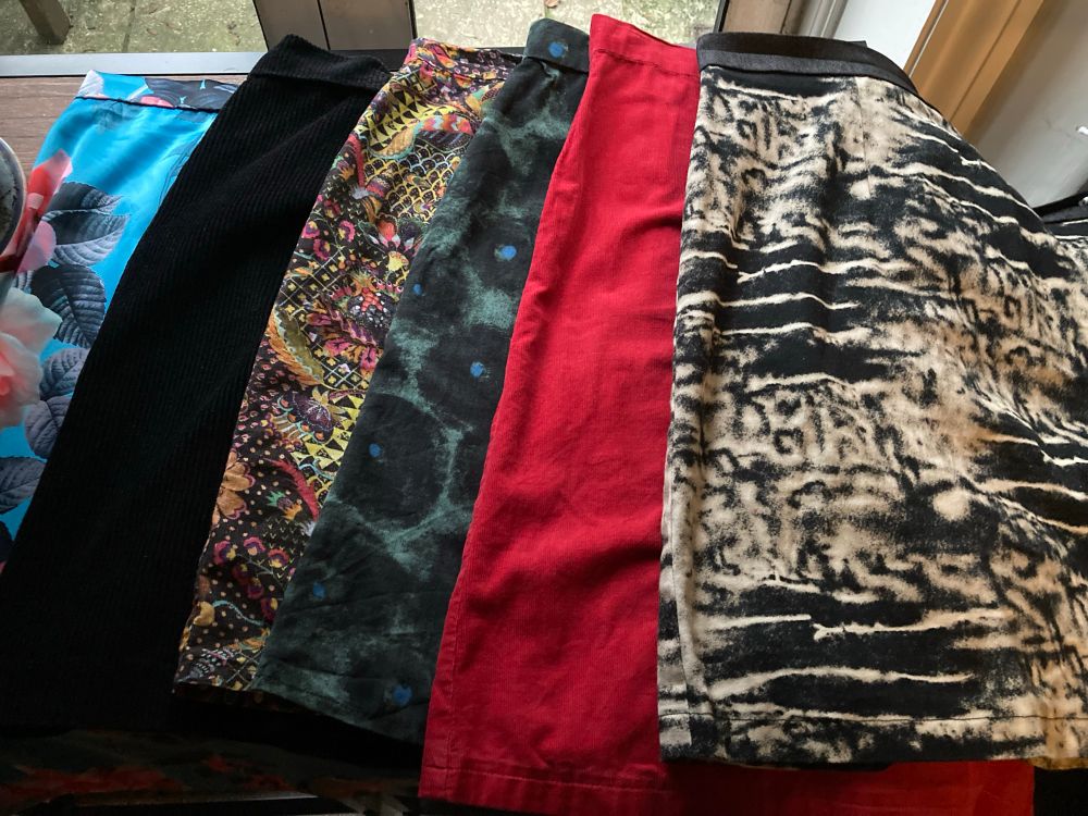 6 A-line skirts from left to right - bright turquoise floral, black corduroy, multi coloured Liberty needlecord, green wool with black circles, red needlecord, black and cream denim
