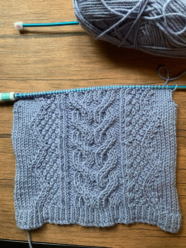 Knitting in progress - pale blue baby jumper with central cable section