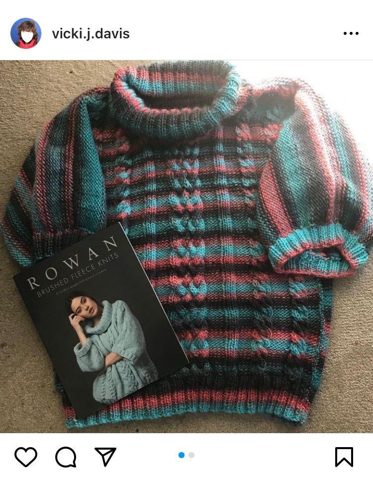 Stripy short sleeved jumper in shades of black, turquoise and pink - oversized with cables up the front and a big roll neck collar - alongside pattern book showing what it would look like in a plain colour 