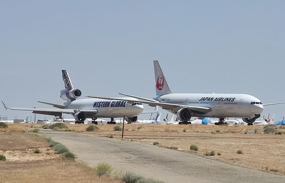 Western Global MD11 and JAL777 seen in the foreground at Mojave with multiple other stored aircraft in the distance behind. 