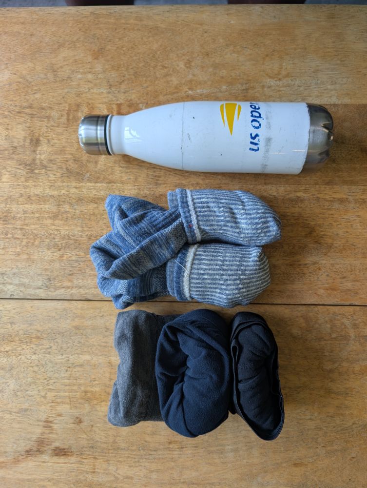 A water bottle, two pairs of socks, three pairs of underwear on a table. These were eliminated from my pack because of redundancy.