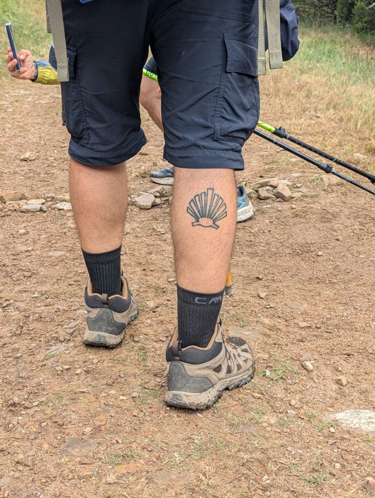A tattoo of the shell symbolizing El Camino on a fellow traveler's calf
