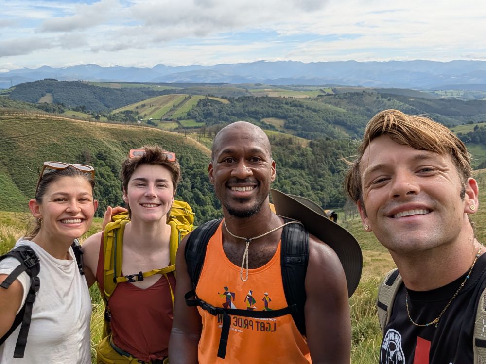 Group photo with rolling hills, farmland, X mountains in the backdrop
