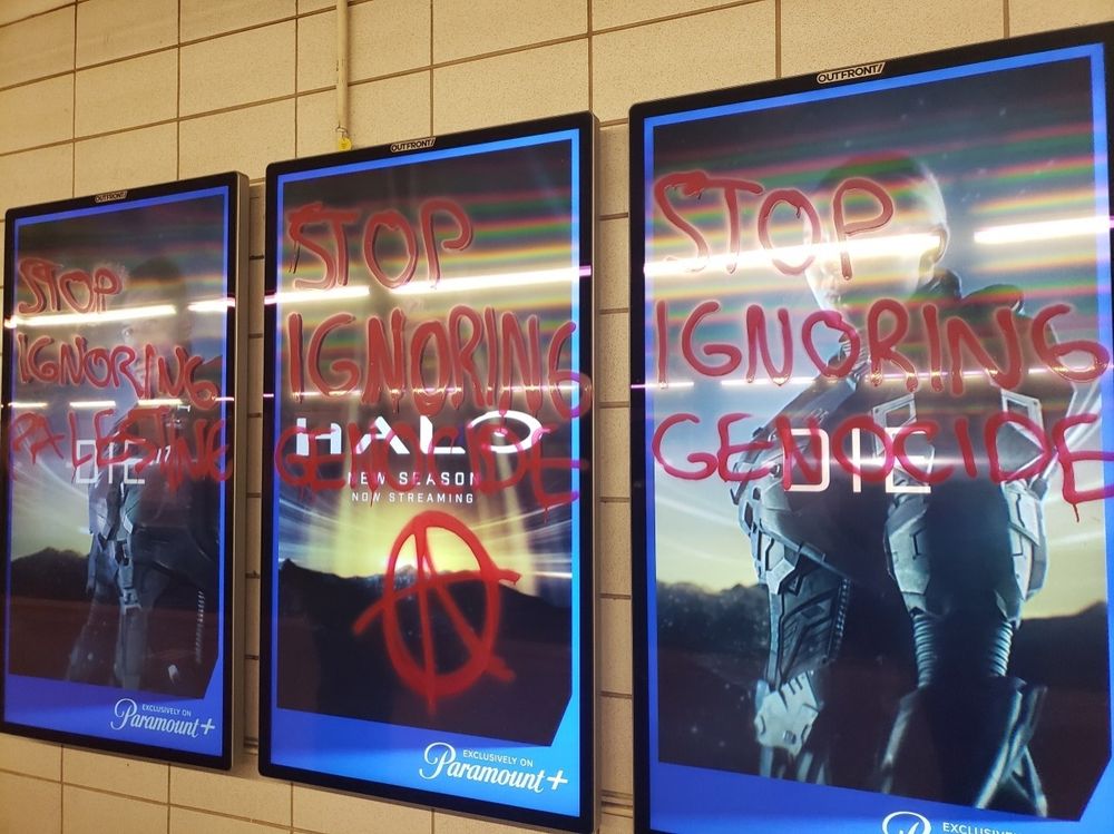 "Stop ignoring genocide" written on ad spaces using red paint