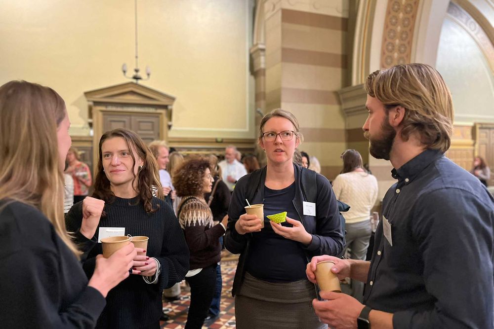 Four attendees mingling during a fika break at U-CARE Venue 2024. 
