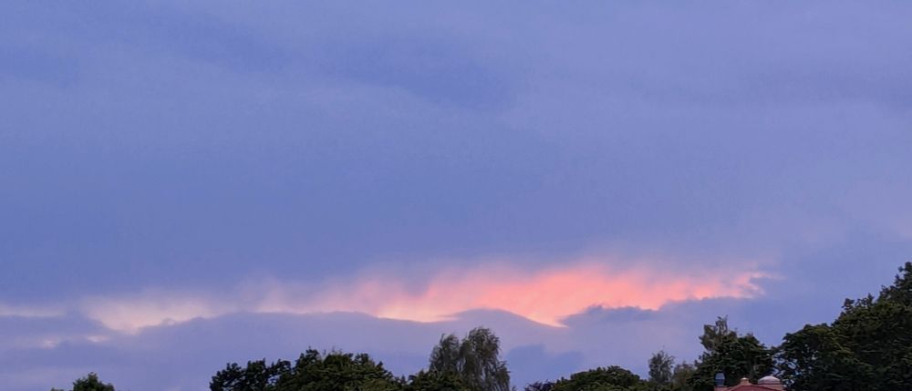 An overcast sky near dusk, with what looks like a cut across the horizon where light spills out.