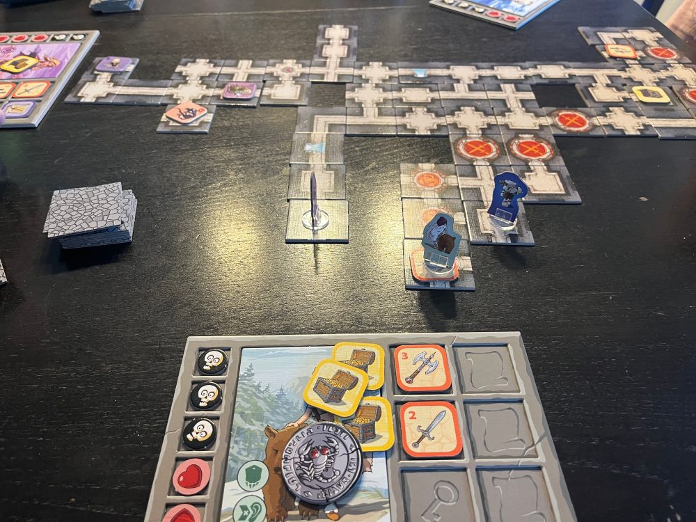 Ein Brettspiel, Karak. Eine Art Dungeon Crawler für Kinder. Auf meinem Brett liegen gute Waffen und drei Schätze, aber auch ein Fluchmarker der mir verbietet meine Character Fähigkeiten zu nutzen