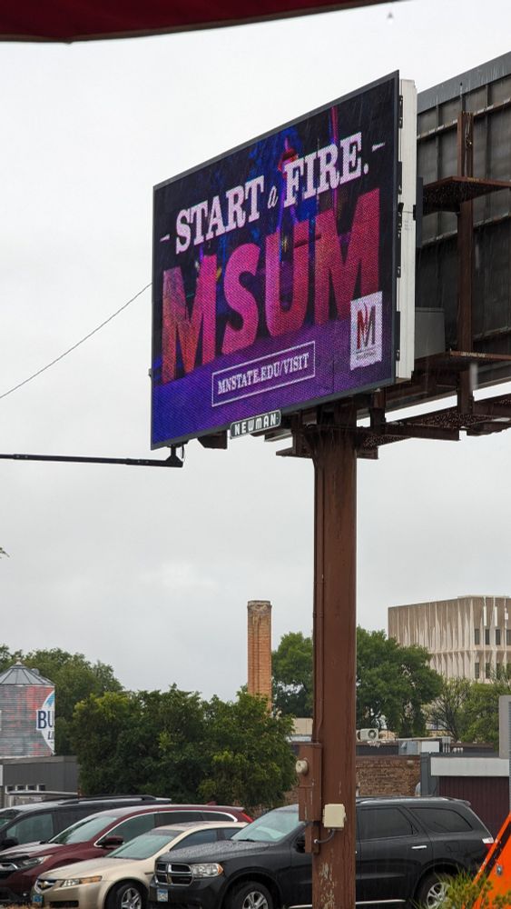 Billboard reading "Start a Fire - MSUM," implying I'm going to college to start fires 