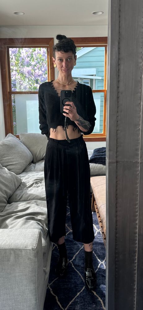 Fetish Sensory Artist Moss Spider stands in front of full length mirror taking a selfie. They are dressed in all black; tattered crop sweater, crop high waist slacks, and patent black loafers. Sir Spider is looking thirsty, as they are about to play with a favorite toy, a favorited sub. 

#allblackfashion #queerfashion #nonbinary #dom #domme #fetish #sadist #impactplay #bondage #dbsm #prodomme #queerkink #queerartist