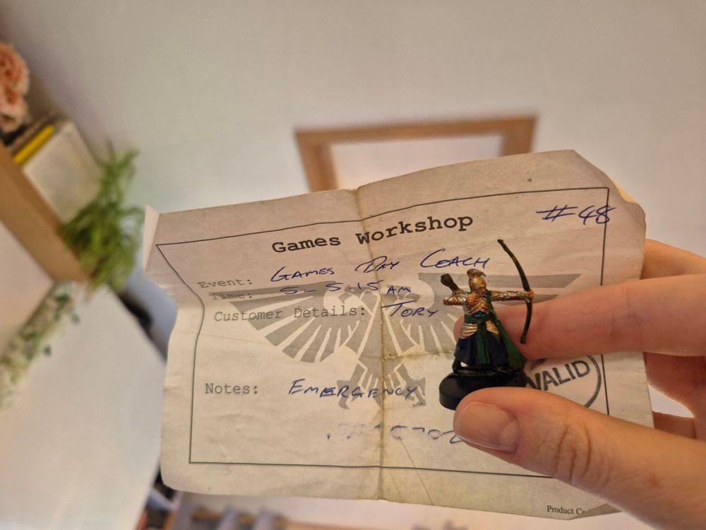 Tory holds a Games day coach ticket and a High Elf Archer