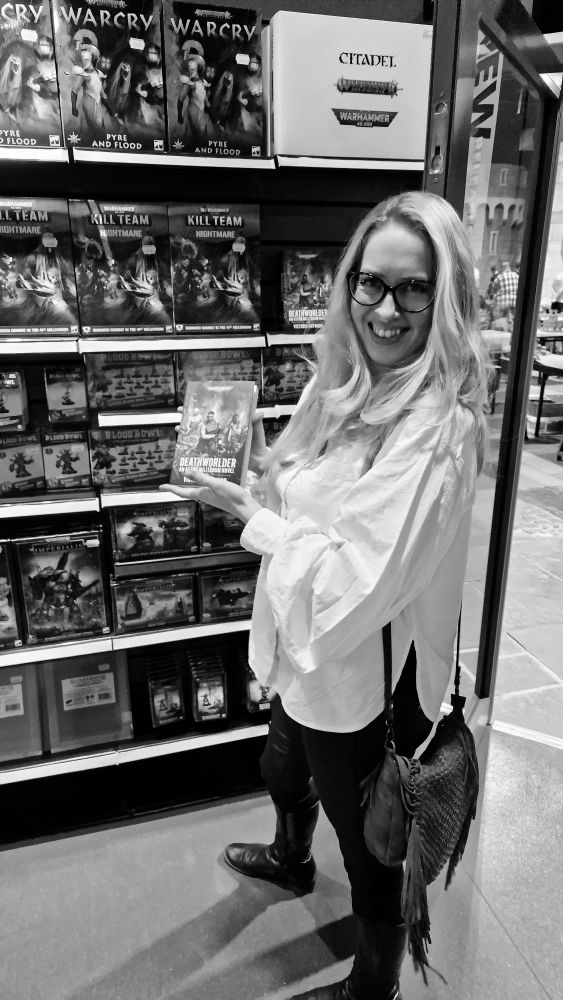 Tory proudly holds a copy of her debut Black Library Astra Militarum Catachans versus Tyranids novel, Deathworlder in the Warhammer World Store