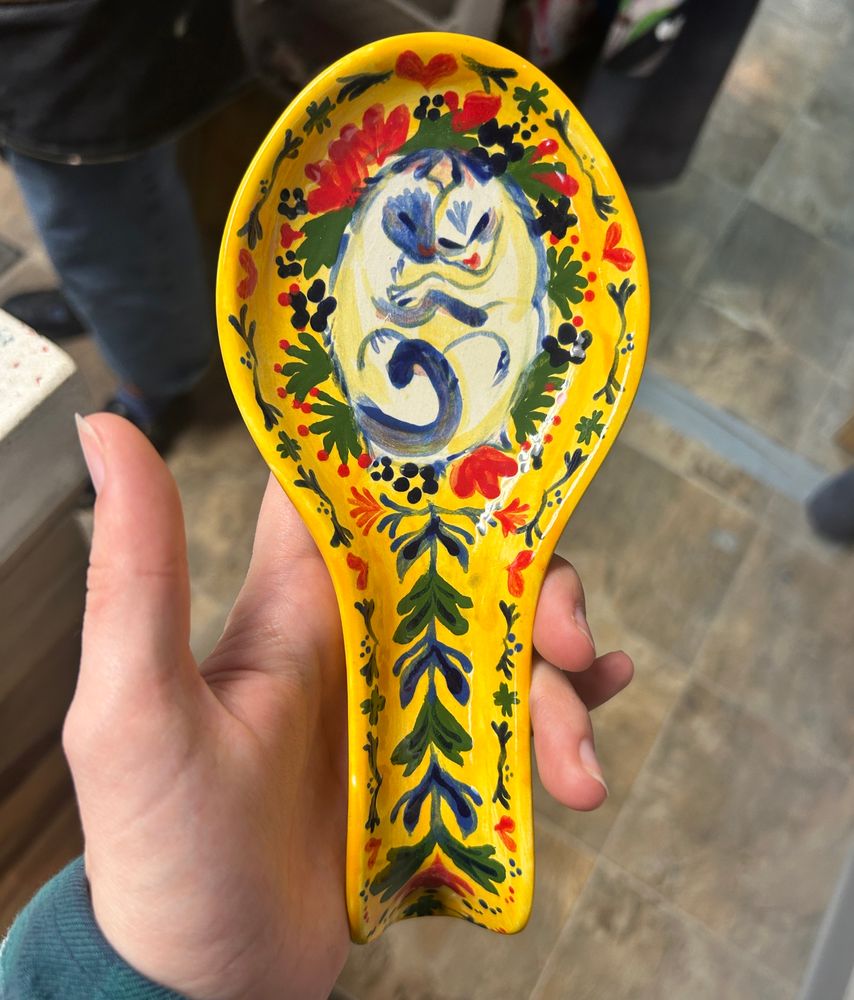 Fired ceramic spoon holder with two kittens cuddling in the middle.