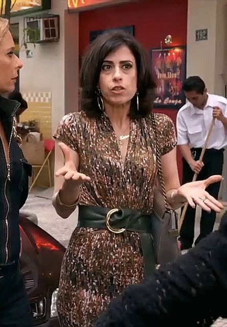 a woman in a leopard print dress is talking to another woman in front of a sign that says 192