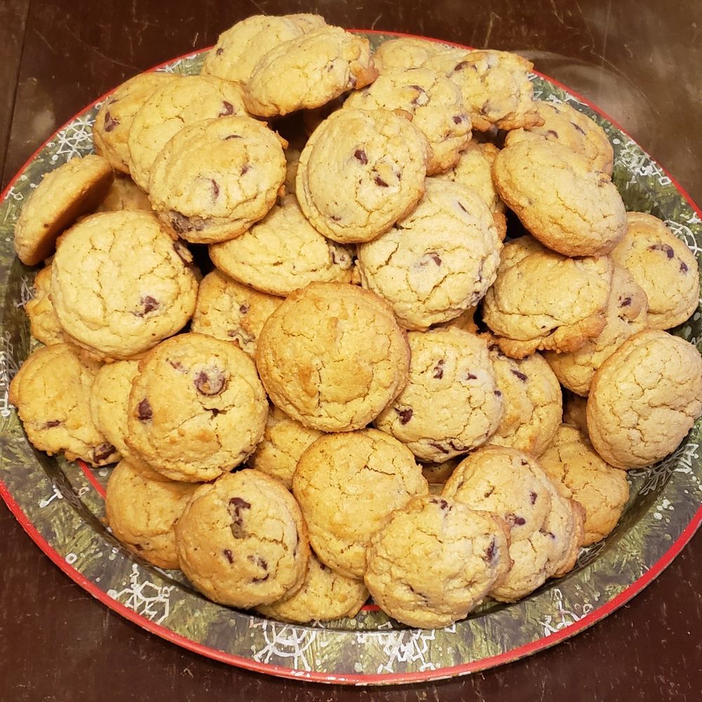 Chocolate chip cookies on a green platter with snowflakes.