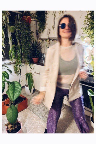 person dancing in a kitchen with tons of plants in the background