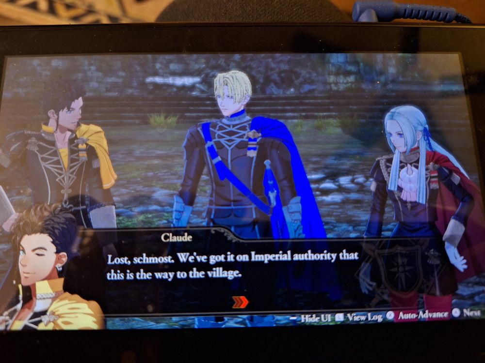 A poorly cropped picture of a Nintendo Switch showing a scene from Fire Emblem Warriors: Three Hopes, featuring Claude, Dimitri, and Edelgard who definitely were all just fucking in the woods before they got lost "looking for a village" (to fuck in)