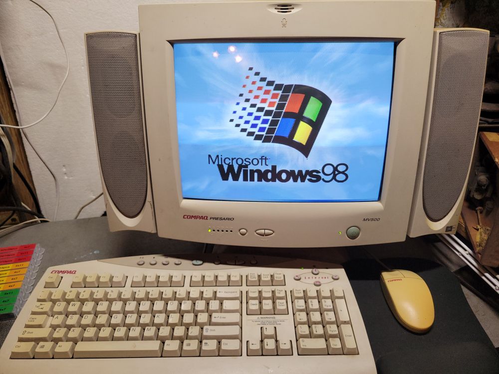 Windows 98 logo displayed on a 1998 Compaq PC's matching CRT monitor, as well as keyboard & mouse.