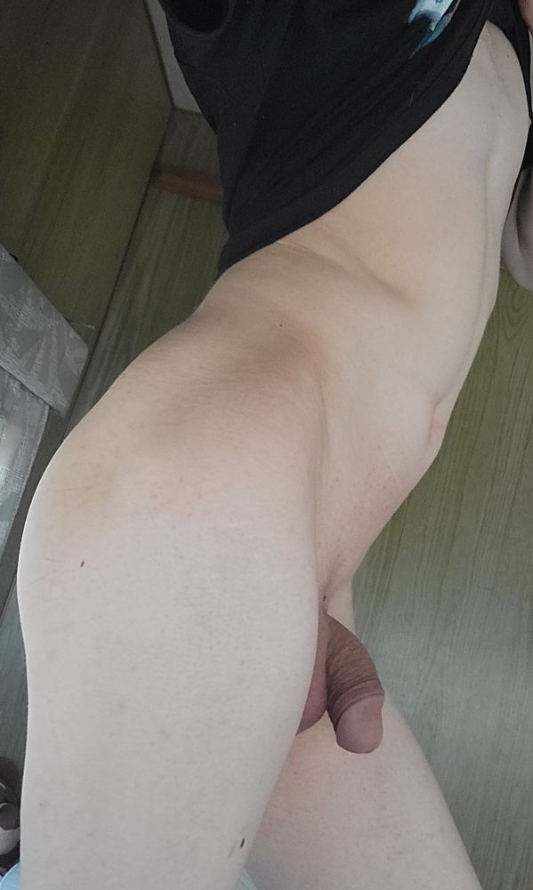 A side-view of me standing with my shirt lifted and my back arched to accentuate the curvature of my butt,my cock is poking out from around my thigh