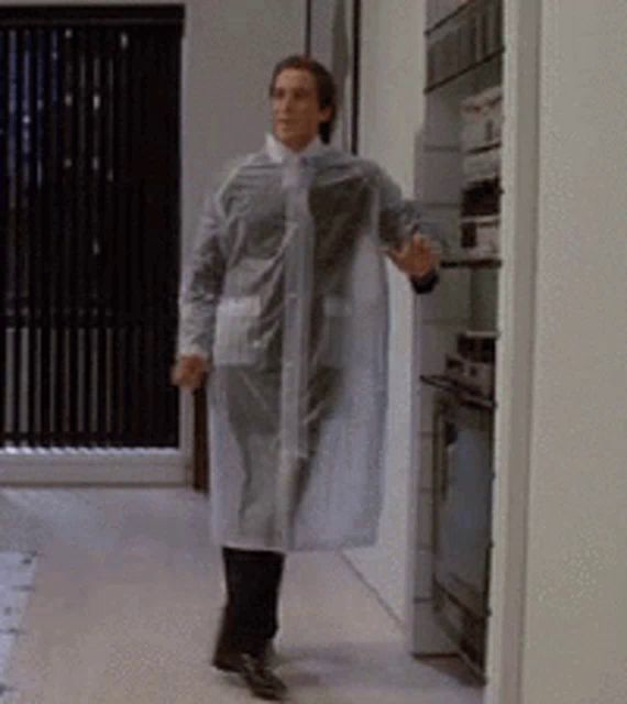 a man wearing a clear plastic coat is walking through a hallway