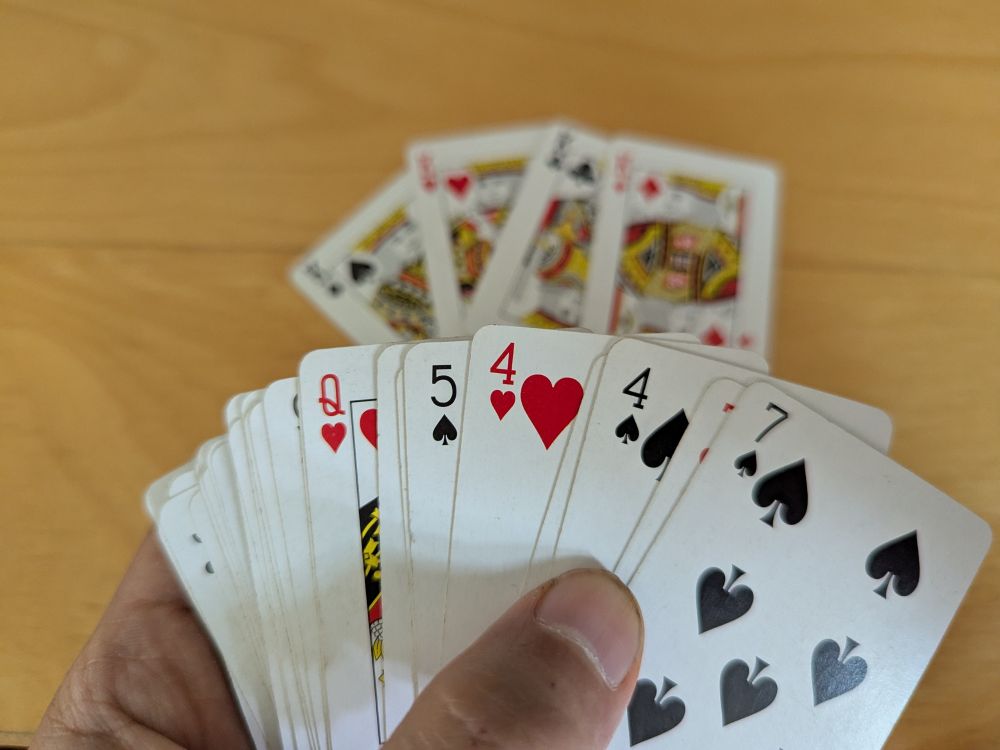 A hand of cards; four kings are out of the hand, on the table