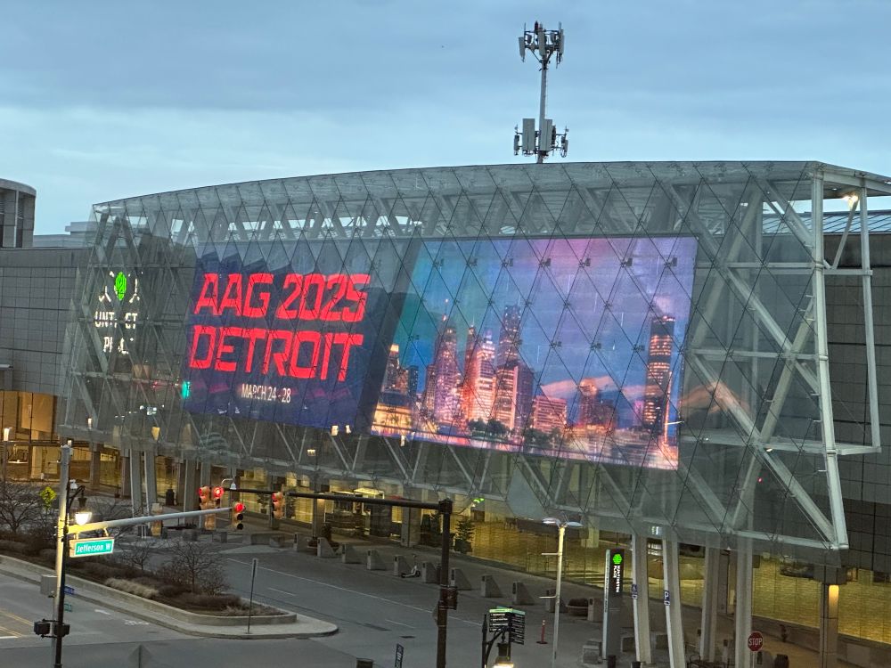 LED sign outside of a building with a picture of a city skyline. 

AAG 2025
DETROIT
MARCH 24 - 28