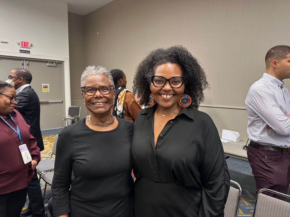 Two women smiling at the camera. 