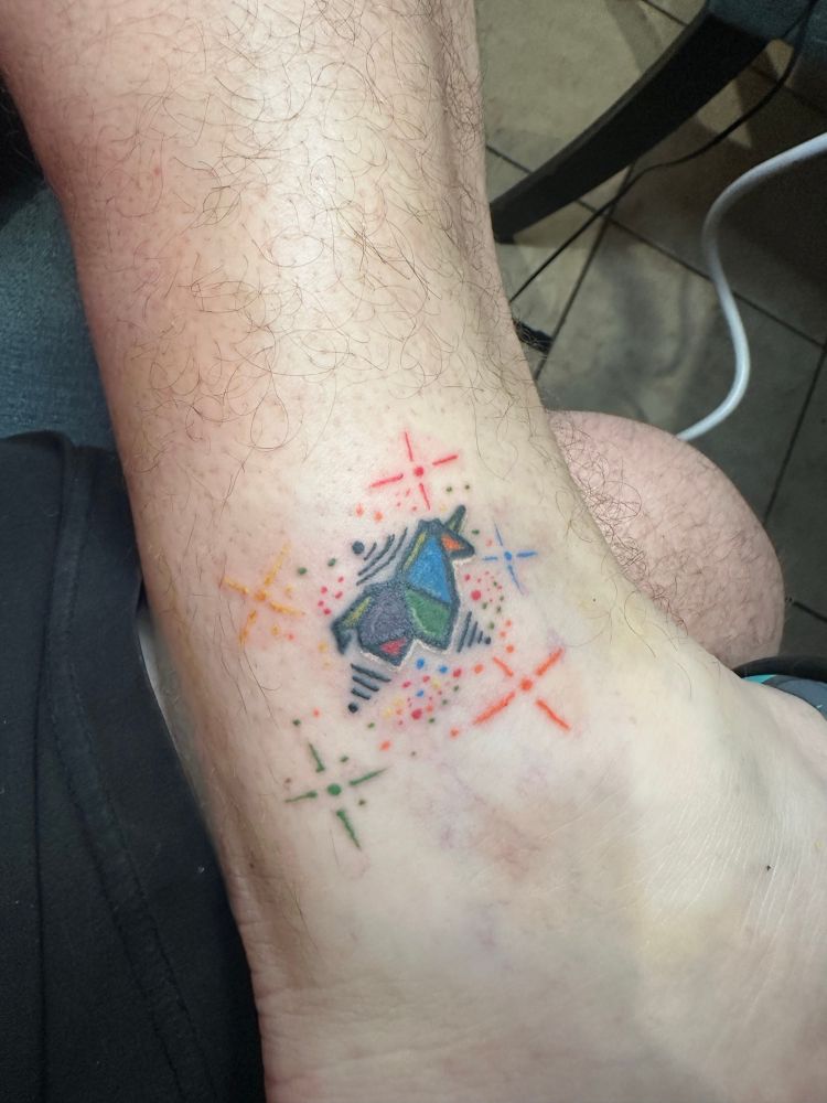 Small geometric unicorn with stars in rainbow colors. 