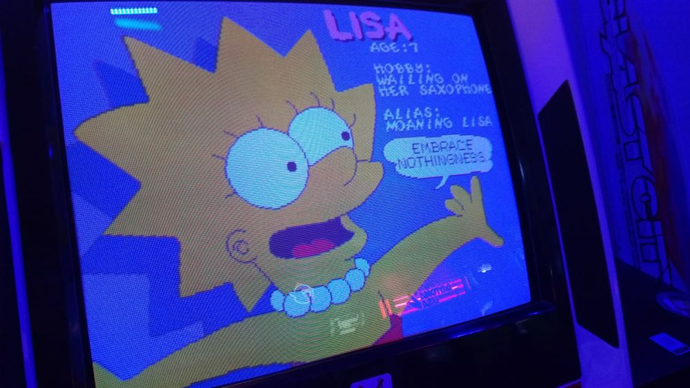 photo of an arcade cabinet with the Simpsons arcade game. close-up shot of Lisa Simpson from the game's attract mode with her looking excited and saying "Embrace nothingness!"