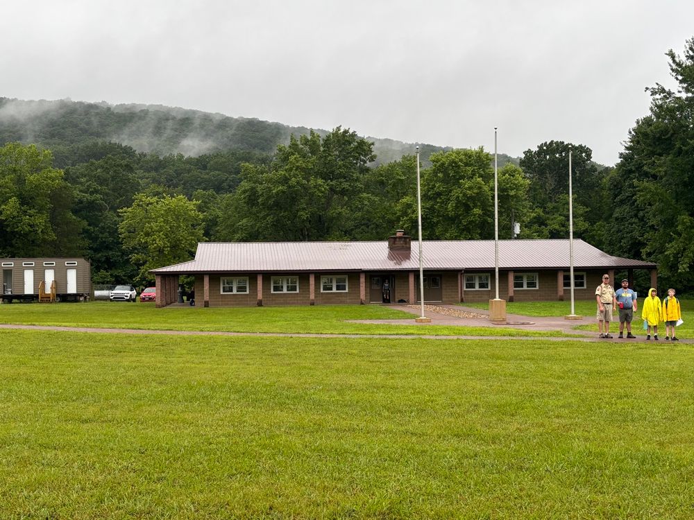 Picture of camp dining lodge with a cloudy mist over small mountain.