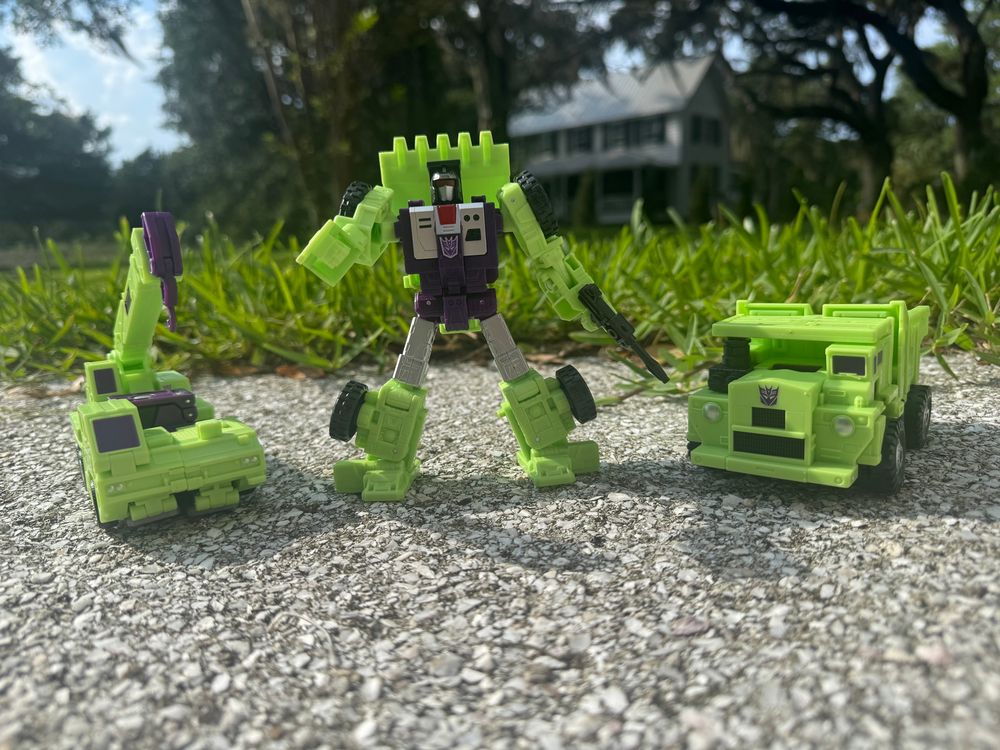 Scrapper (middle), flanked on either shade by Hook (left) and Longhaul (right), who are both in vehicle mode.