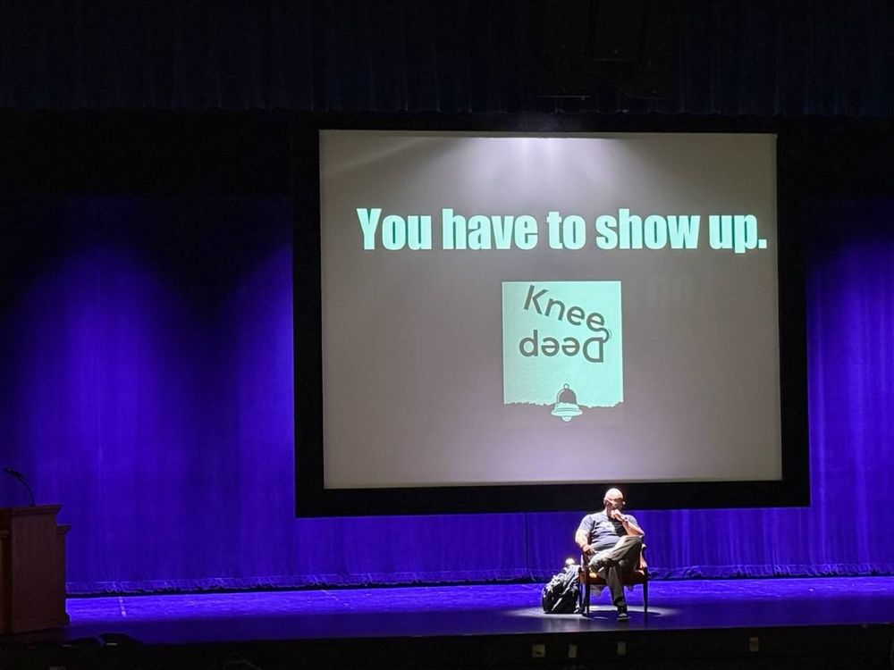 Dr. Shawn Foster on stage discussing his book and expressing the importance of showing up