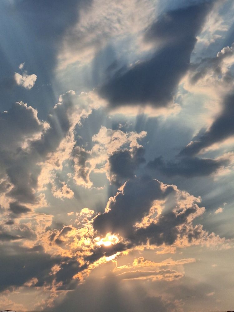 Just the sun in the sky behind said clouds 