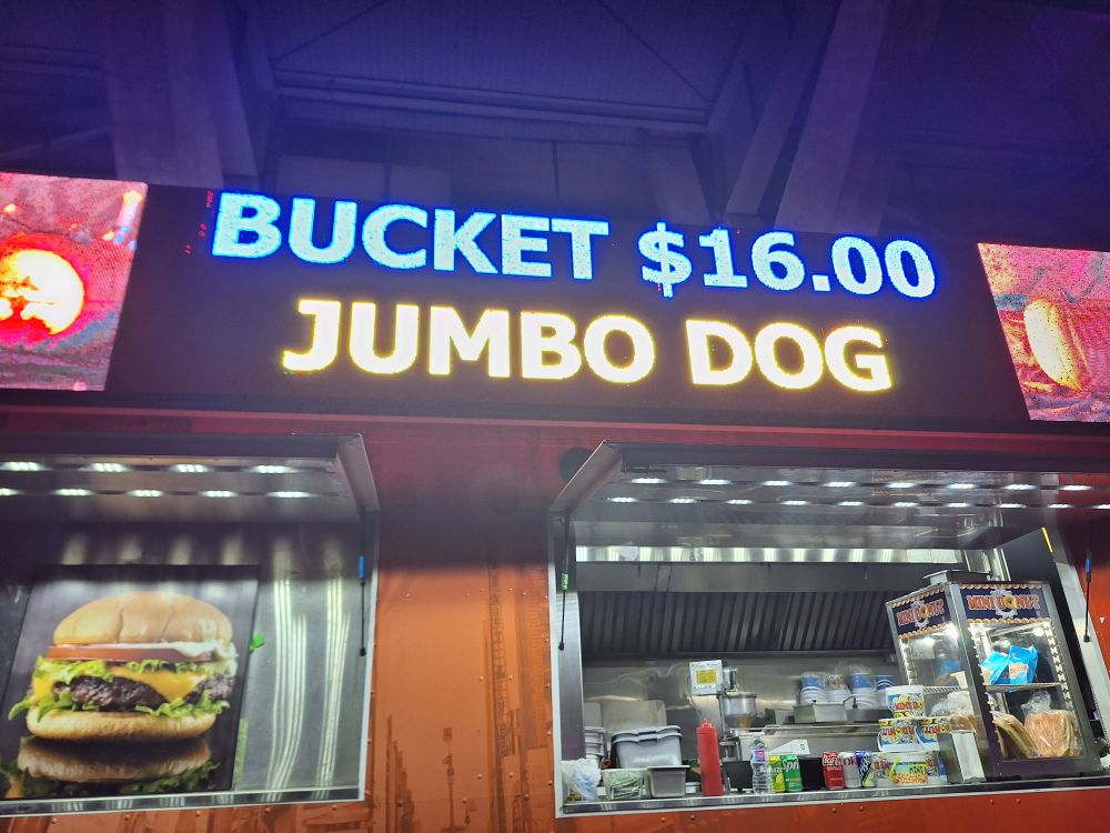 light display on side of food truck that sells mini donuts and hot dogs, currently says "BUCKET $16 JUMBO DOG"