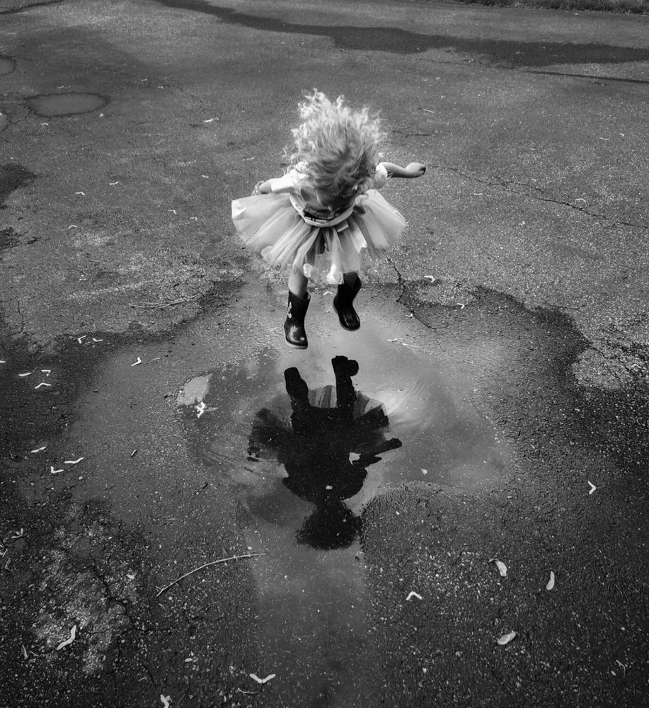 Little girl in a pretty angel dress jumping into a puddle ❤️