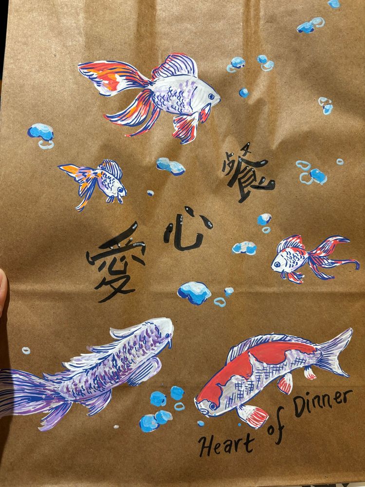 爱心餐 on a brown paper bag decorated with goldfish & koi