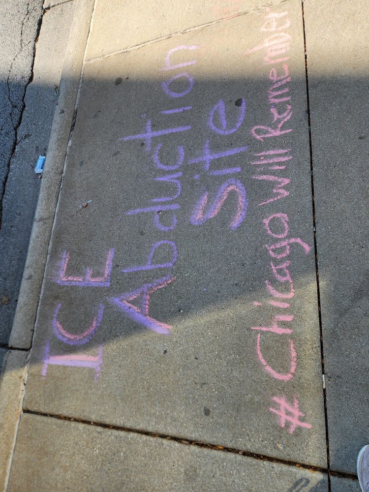 Chalk sidewalk drawing saying "ICE abduction site. Chicago will remember "