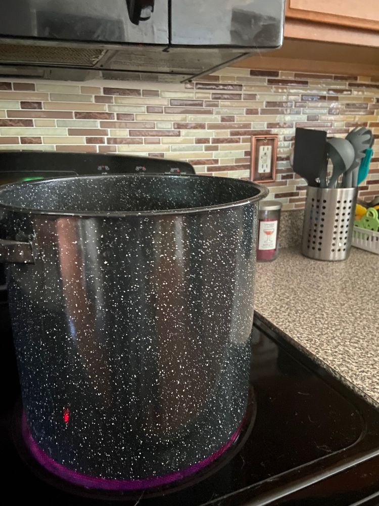 Large black stock pot with white speckles. 
