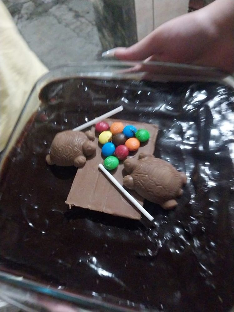 pavê com duas tortuguitas em cima jogando sinuca. a mesa de sinuca é um kitkat virado pra baixo, as bolas são m&m's e os tacos são cabinhos de pirulito (se não me engano)