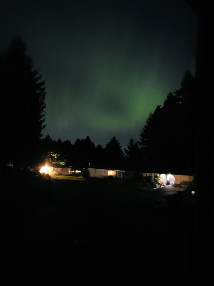 An image of the sky with a faint wispy green glow from the aurora borealis.