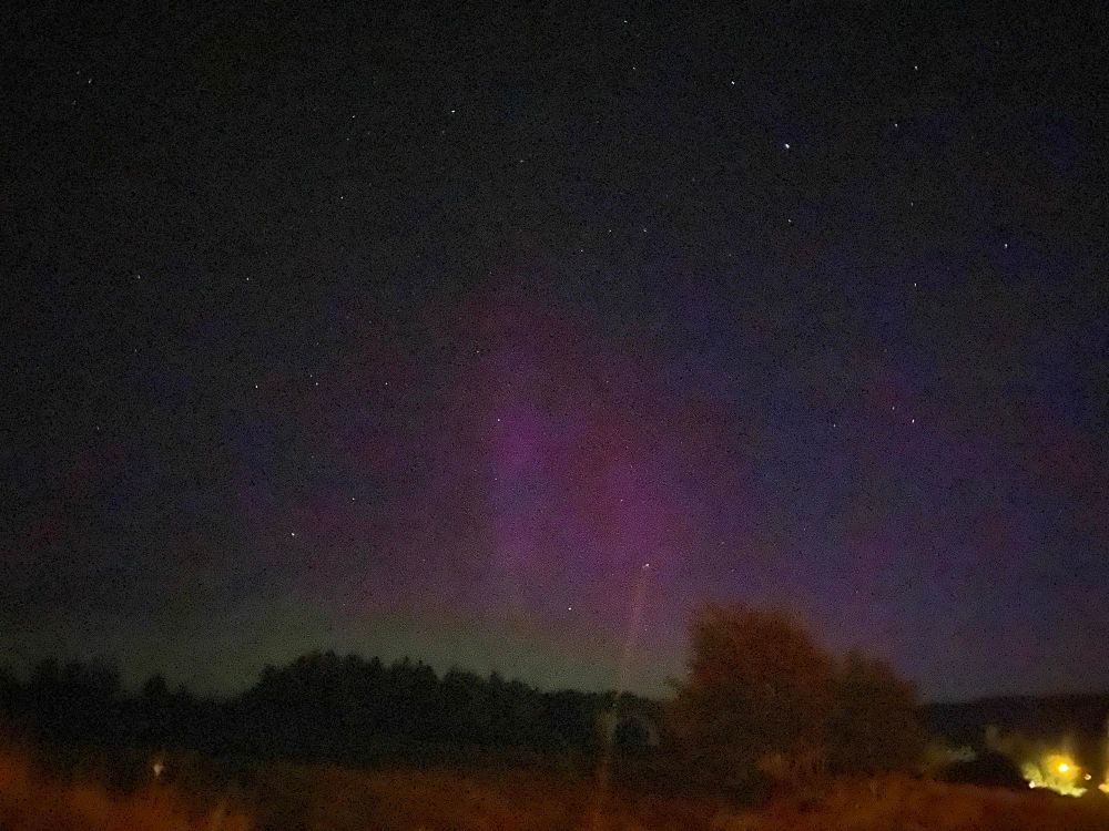 Yellow glow above the horizon and tall red beams. 