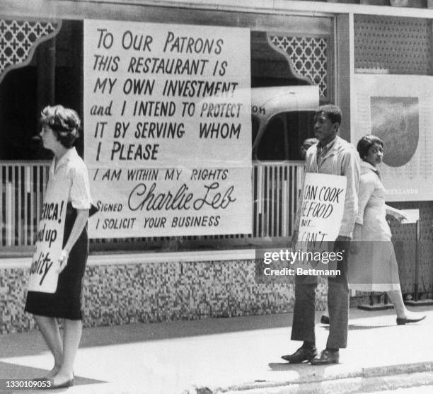 People protesting outside of a business with a large sign in the window, which reads "TO OUR PATRONS THIS RESTAURANT IS MY OWN INVESTMENT and I INTEND TO PROTECT IT BY SERVING WHOM I PLEASE I AM WITHIN MY RIGHTS Signed Charlie Leb I SOLICIT YOUR BUSINESS"