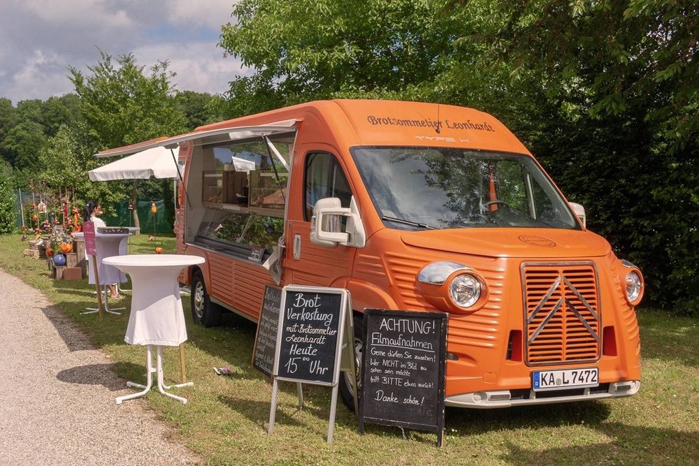 A modern Citroen van modified to look like a classic H Type, in a food truck specification, painted orange